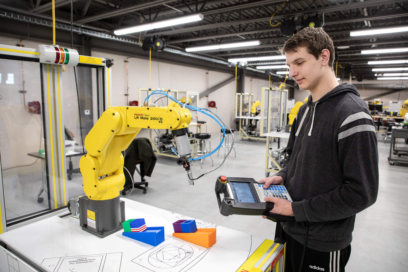 Student working with Fanuc robot in advanced manufacturing environment