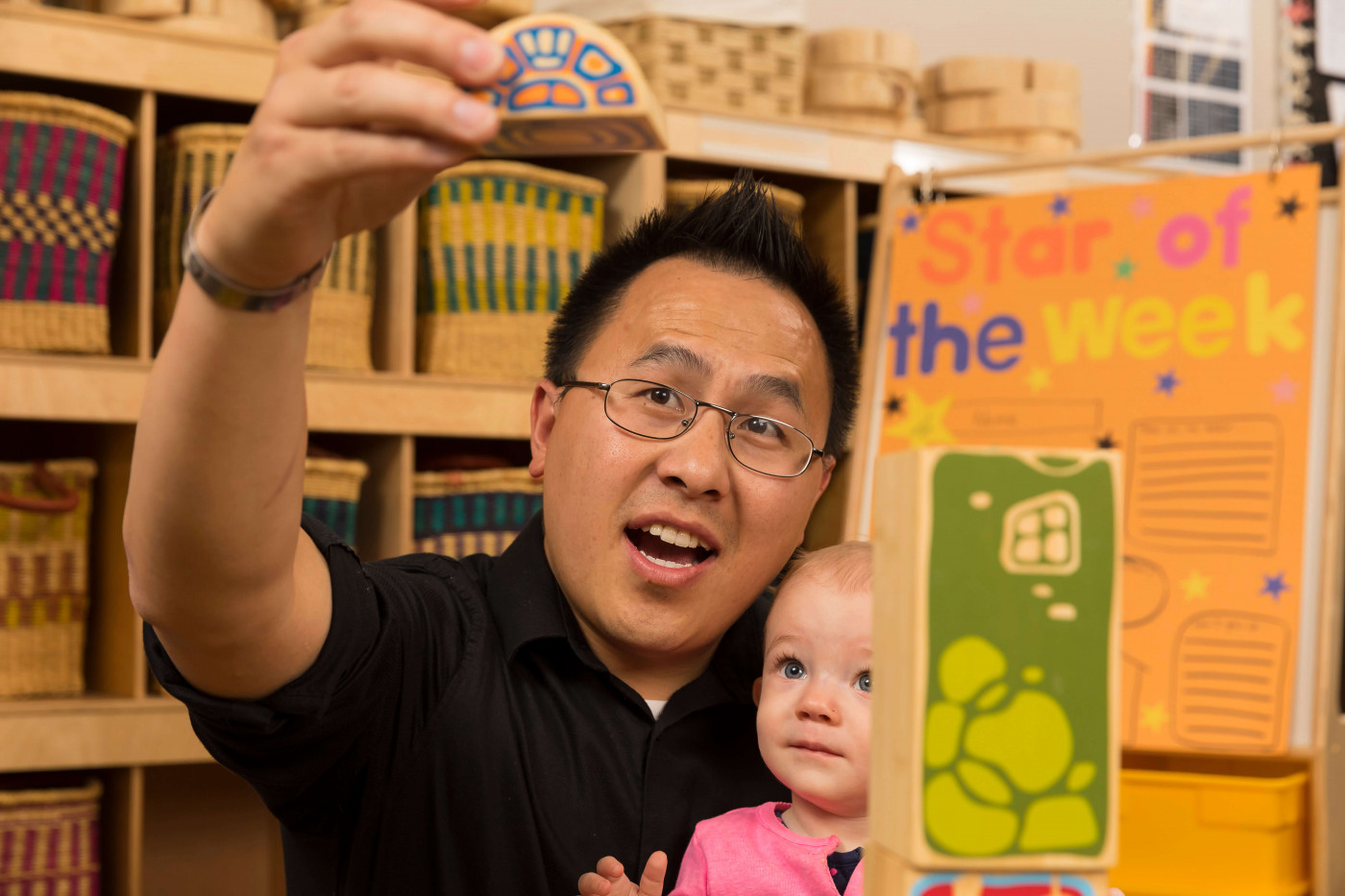 Early Childhood teacher holding toys up to young child