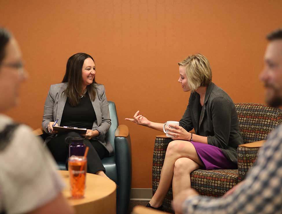 Two people chatting in office common area