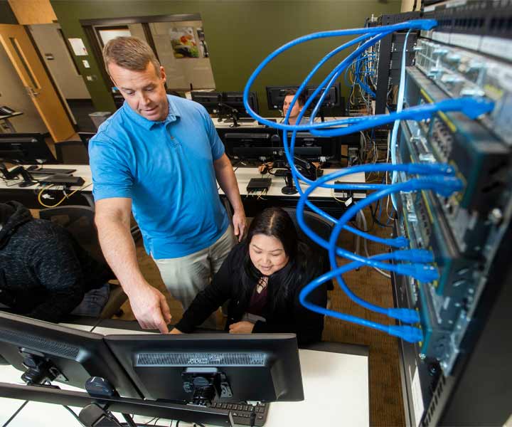 Information technology instructor helping a student