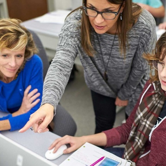 Instructor showing something on computer screen to students