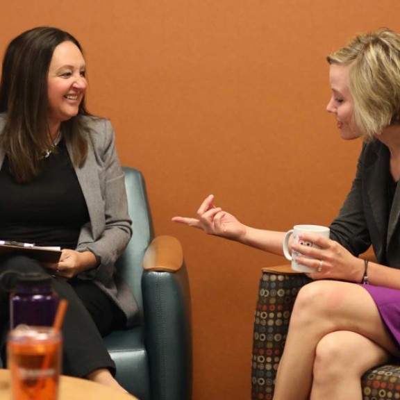 Two people chatting in campus common area