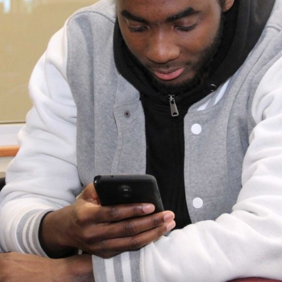 Student in common area looking at mobile phone