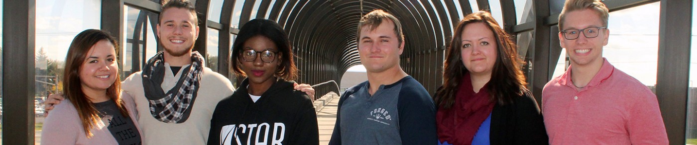 Six students smiling together on campus