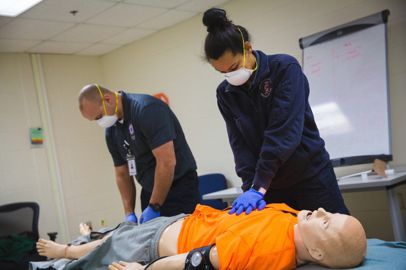 EMT students practicing CPR using proper PPE