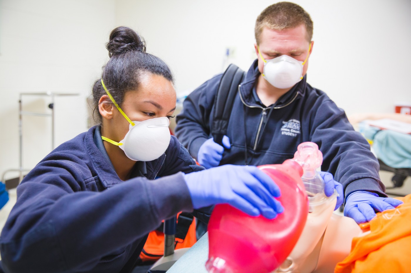 EMT students practicing CPR with proper PPE