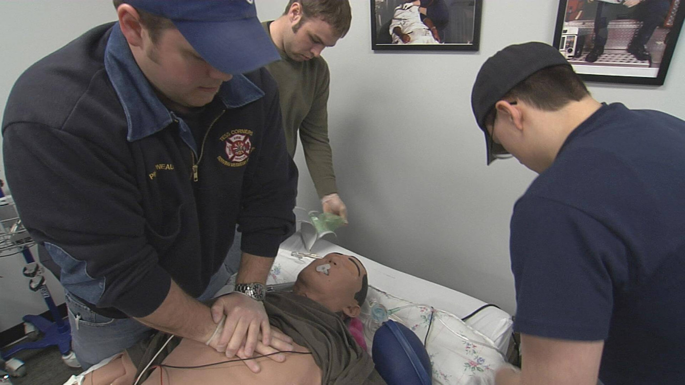 Several Fire Paramedic students are practicing their skills on a manikin
