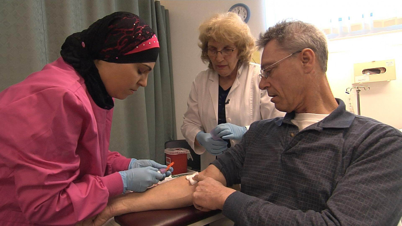 Technician drawing blood from patient