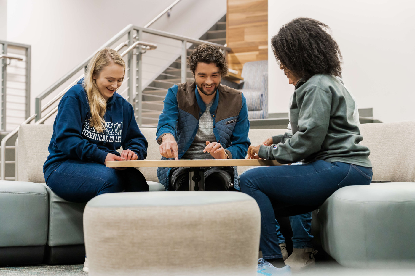 Three students studying and chatting in the student lounge