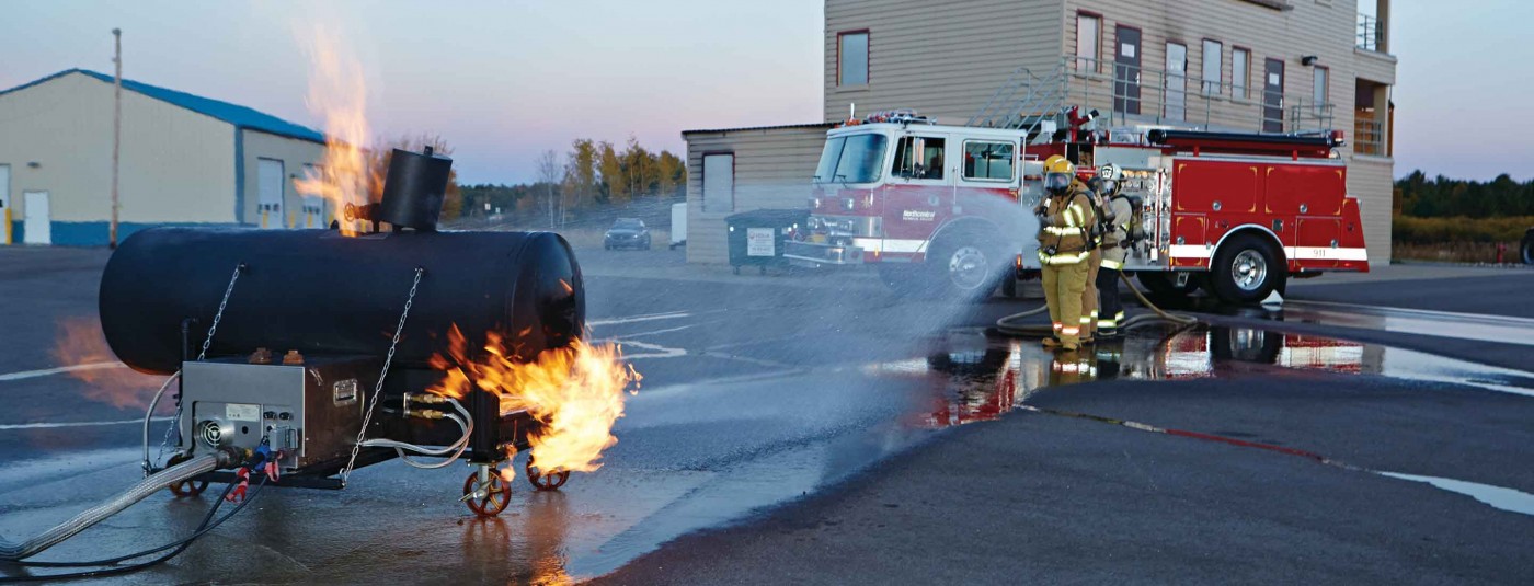 Fire fighter students extinguishing gas fire scenario in parking lot