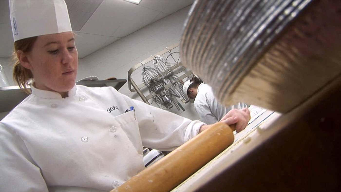 A baker rolling out dough
