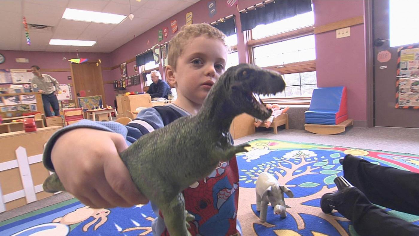 preschool-aged child playing with a dinosaur